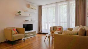 Una sala de estar con dos sillas y un televisor. en Бяла Виста Клиф - Byala Vista Cliff, en Byala