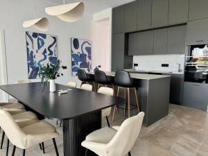 a kitchen with a black table and chairs at Poniente Beach House in Chiclana de la Frontera