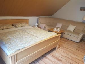 a bedroom with a bed and a couch at Ferienwohnung Aurich Ostfriesland in Aurich