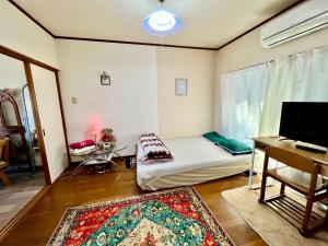a room with a bed and a desk and a tv at Shirahama in Miyazaki