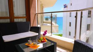 Habitación con mesa y balcón con vistas al océano. en Бяла Виста Клиф - Byala Vista Cliff, en Byala