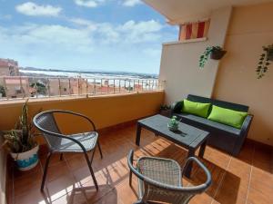 a balcony with chairs and a couch and a table at Villasara 3D Parking gratis in Aguadulce