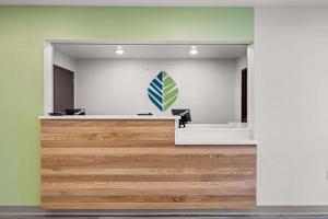 una hall con un cartello verde e bianco sul muro di WoodSpring Suites Loves Park - Rockford a Loves Park