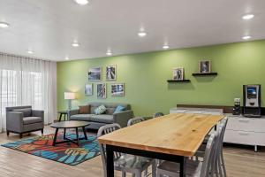 un soggiorno con tavolo e parete verde di WoodSpring Suites Loves Park - Rockford a Loves Park