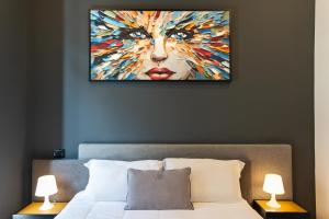 a bedroom with a painting of a woman at Gram Suites in Naples