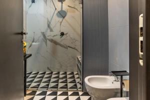 a bathroom with a shower and a toilet and a sink at Gram Suites in Naples