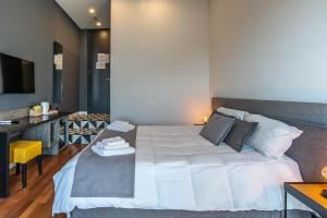 a bedroom with a large white bed and a desk at Gram Suites in Naples