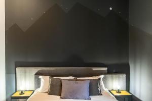 a bedroom with a black wall and a bed with pillows at Gram Suites in Naples