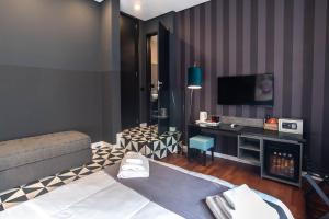 a living room with a bed and a tv at Gram Suites in Naples