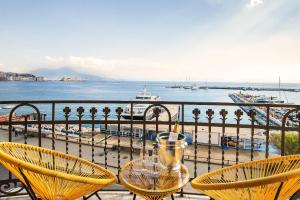 a table and chairs on a balcony overlooking the water at Gram Suites in Naples
