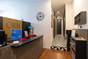an office with a reception desk and a clock on the wall at Gram Suites in Naples