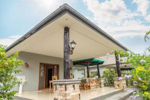 een huis met een patio met tafels en stoelen bij Extreme Adventure Park in Busika