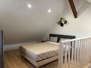 a bedroom with a bed and a crib at Appartement Sous les Etoiles pour 6 personnes in Saint-Nectaire