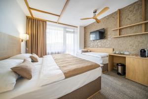 鲁哈科维斯Hotel Adamantino的一间有两张床和一台电视的酒店房间