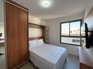 a small bedroom with a bed and a window at Um quarto - Barra Conceito in Salvador