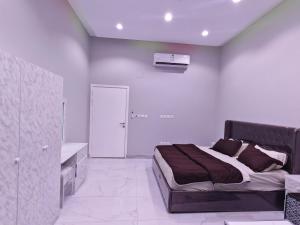 una camera con un grande letto e una parete bianca di Home1 2BR هوم1 شقة غرفتين بمدخل مستقل تبعد اقل من 5 كلم عن الحرم النبوي a Medina