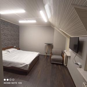 a bedroom with a bed and a flat screen tv at Friends Hostel in Chişinău