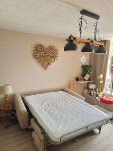 a bed in a room with a heart on the wall at Chaleureux studio pied des pistes Les Glovettes VILLARD DE LANS in Villard-de-Lans
