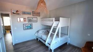 ein weißes Etagenbett in einem Zimmer mit einer Leiter in der Unterkunft Sea-scape - De Panne - spacieux appartement très bien situé avec vue sur mer in De Panne