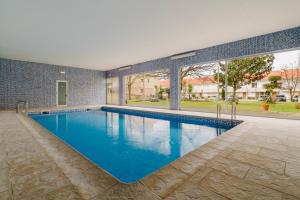 Una gran piscina con agua azul en una casa. en Paradise Villa, en Esposende