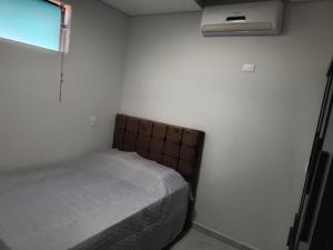 a small bedroom with a bed and a window at Apartamento 1 andar in Bebedouro