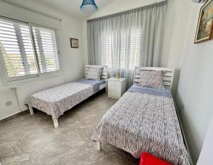 two beds in a room with two windows at Villa M & S in Coral Bay +23 photos