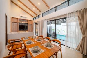 a dining room with a wooden table and chairs at The marin poolvilla aonang in Ban Chong Phli +1 photo