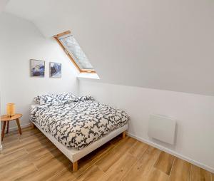 ein Schlafzimmer mit einem Bett und einem Dachfenster in der Unterkunft La perle de Montargis - Charmant T2 in Montargis + 6 Fotos