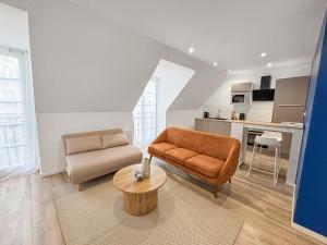 ein Wohnzimmer mit Couch und Tisch in der Unterkunft La perle de Montargis - Charmant T2 in Montargis