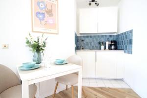 a kitchen with a white table and chairs at Zentrumsnahe Ferienwohnung Grüne Tanne WLAN, kostenloser PKW Parkplatz , zwei Betten, Schlafcouch, Küche in Jena