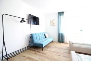 a blue couch in a room with a bed at Zentrumsnahe Ferienwohnung Grüne Tanne WLAN, kostenloser PKW Parkplatz , zwei Betten, Schlafcouch, Küche in Jena