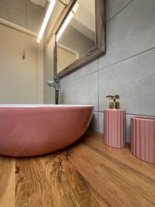 a bathroom with a large red tub on a wooden floor at La maison du 122 in Romorantin