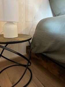 a table with a lamp on it next to a bed at La maison du 122 in Romorantin