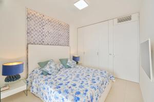 een slaapkamer met een bed met blauwe en witte lakens bij Terrazza Giudecca Gallipoli in Gallipoli