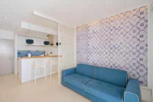 een woonkamer met een blauwe bank en een keuken bij Terrazza Giudecca Gallipoli in Gallipoli