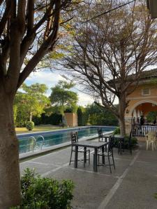 a picnic table and chairs next to a swimming pool at Cute 2 room House with pool access in Tarlac