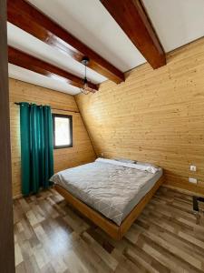 a bedroom with a bed in a wooden wall at Cabana Teo&Matei in Mihăeşti