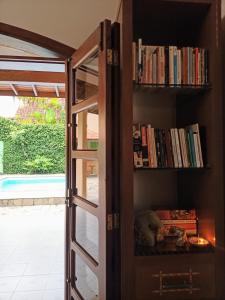 a book shelf with books on it next to a door at Arrasta Hostel quarto compartilhado in São Sebastião
