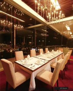 a long table in a restaurant with chairs and tablesearcher at HOTEL HOLITEL PEKANBARU superior double in Pekanbaru