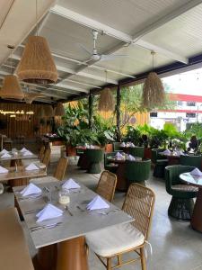 un restaurante con mesa, sillas, mesas y sillón en Hotel Pance 122 Wellness Spa, en Cali