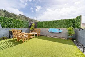 a backyard with a table and chairs and a surfboard at Serenity Costa da Caparica in Almada