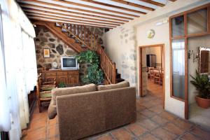 a living room with a couch and a tv at Casa Rural La Bodega in Sonseca