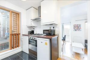 a kitchen with white cabinets and a stove top oven at Flat with London Eye view Big Ben Westminister LM4 in London