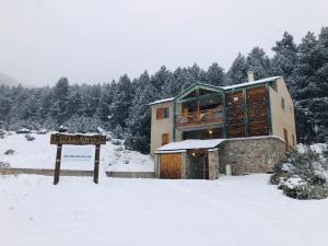 a building with a sign in the snow at Chalet Pla Del Mir in Les Angles