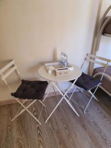 2 sedie e un tavolo bianco e un tavolo con sedie di 4Rooms Guest House Free Wi-Fi a Salerno