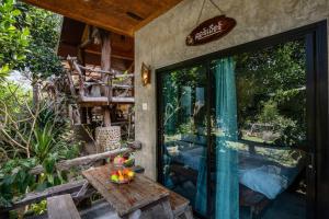a patio with a table and a glass door at คอร์เดียร์ บ้านไร่ริมธารโฮมสเตย์ แก่งกระจาน in Ban Wang Malako