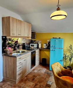 cocina con armarios de madera y nevera azul en Ferienwohnungen Wolfenhaus am See, en Altmünster