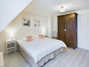 une chambre avec un lit blanc et une armoire en bois dans l'établissement Authentique maison bretonne pour 6 à Plovan, à Plovan