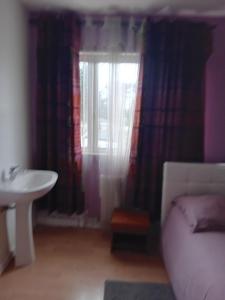 Habitación con cama, lavabo y ventana en Chambre privée dans une maison individuelle, en Ronchin 1 foto más