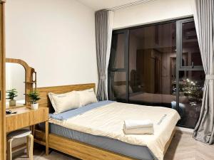 a bedroom with a bed and a desk at Honeymoon homes - Vinhomes Grand Park Quận 9 - 2 phòng ngủ in Gò Công +29 photos
